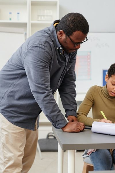 Black Teacher Helping Girl in Class