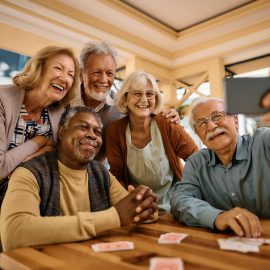 Cheerful senior having fun while taking selfie at retirement community.