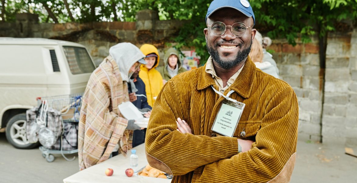 Volunteer helping homeless people outdoors